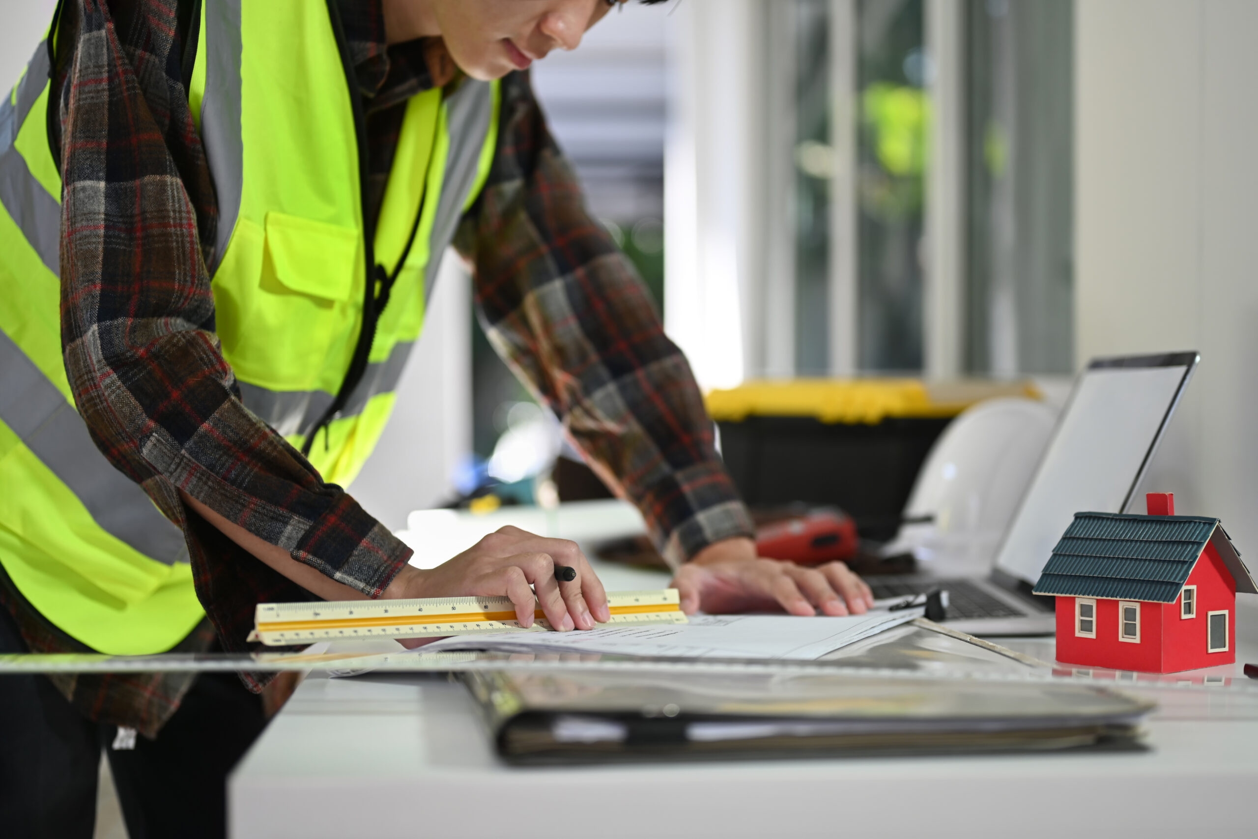 Cropped shot of engineers working with designs, planning development details at structural site.